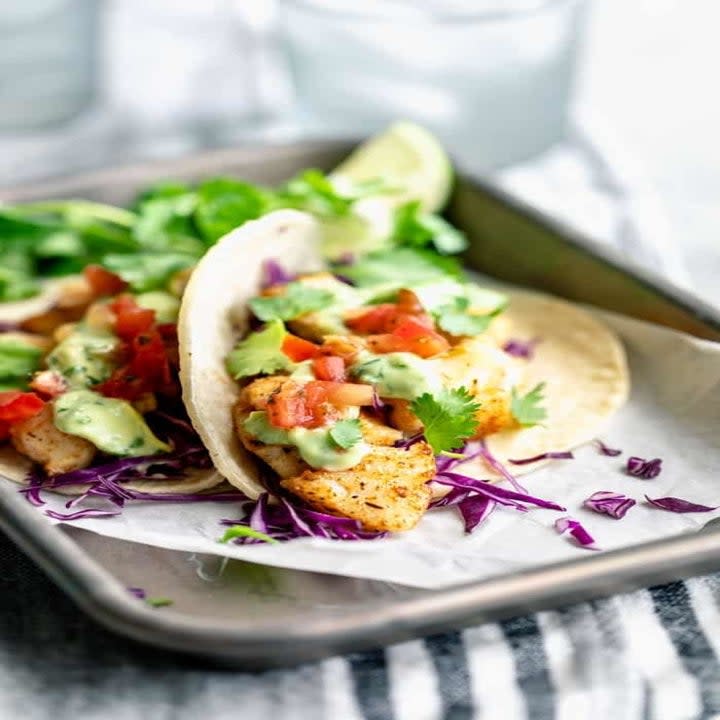 A close-up of white fish tacos with slaw and fresh cilantro.