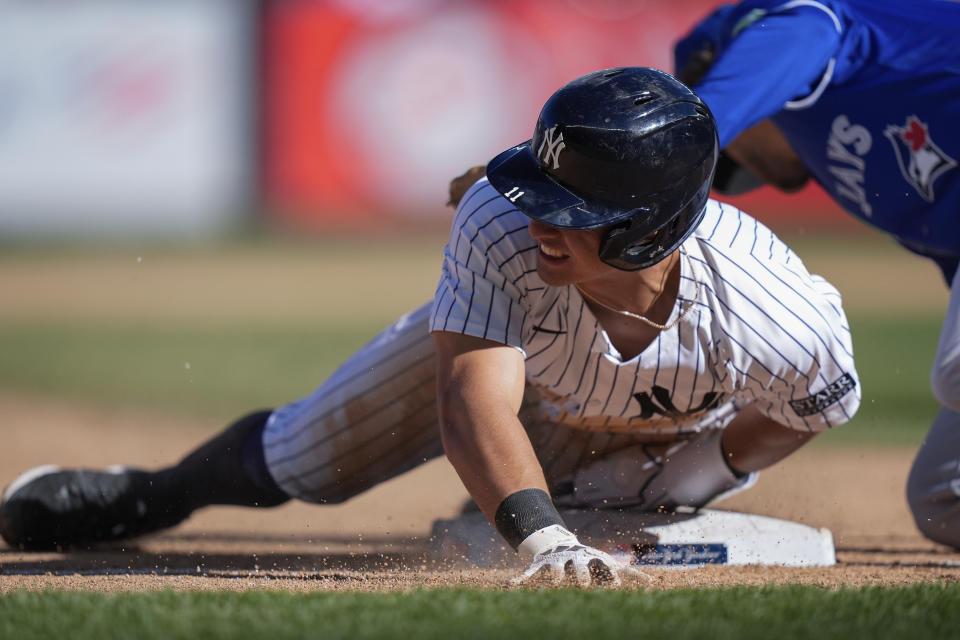 New York Yankees' Anthony Volpe slides past Toronto Blue Jays Ernie Clement to steal third base during the eighth inning of a baseball game Sunday, April 7, 2024, in New York. The Yankees won 8-3. (AP Photo/Frank Franklin II)