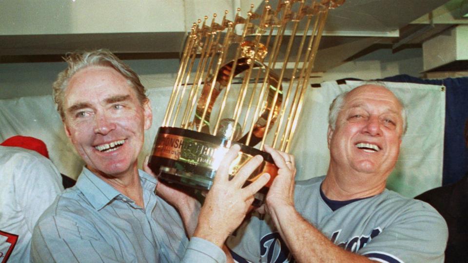 Dodgers manager Tommy Lasorda and Dodgers Fred Claire, Dodger Vice President Fred Claire hoist the World Series trophy.