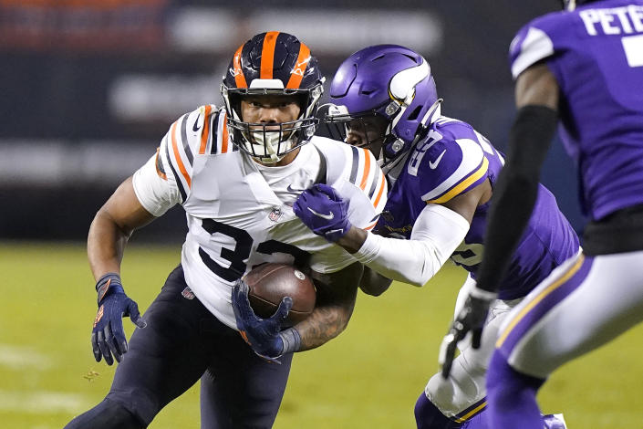 Chicago Bears running back David Montgomery carries the ball as Minnesota Vikings free safety Xavier Woods makes the tackle during the first half of an NFL football game Monday, Dec. 20, 2021, in Chicago. (AP Photo/Nam Y. Huh)