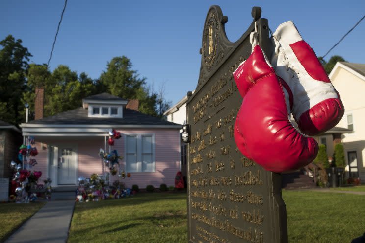 Boxing gloves hang from a historical marker in front of Muhammad Ali's childhood home on Grand Avenue on Friday in Louisville, Ky. (Photo: Ty Wright/Getty Images)