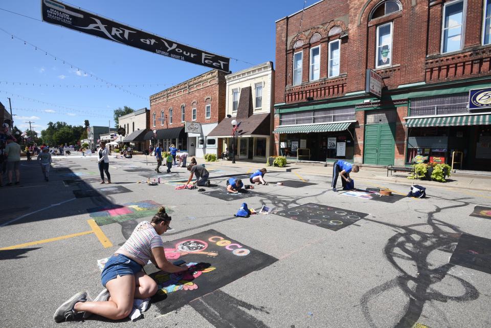 Artists of all ages and levels of artistic ability line South Lane Street in downtown Blissfield during the 2019 Art at Your Feet street art festival. The art festival returns to South Lane Street Saturday, Aug. 20.
