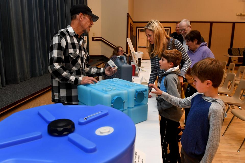 Donnie Clapp gives an overview on water storage and purification to Heather Seguine and children Nolan and Emmett during the Emergency Preparedness Fair at the Church of Jesus Christ of Latter-day Saints in Thousand Oaks on Saturday.