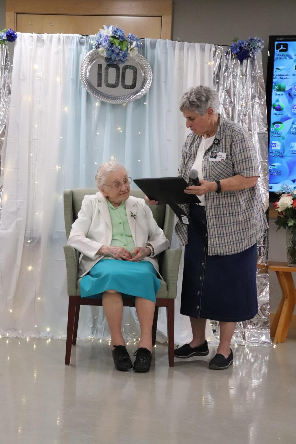 Adrian Dominican Sister Judy Friedel, chapter prioress of Holy Rosary Mission Chapter, makes a presentation to Sister Miriam Joseph Lekan during a celebration of Lekan's 100th birthday April 12.