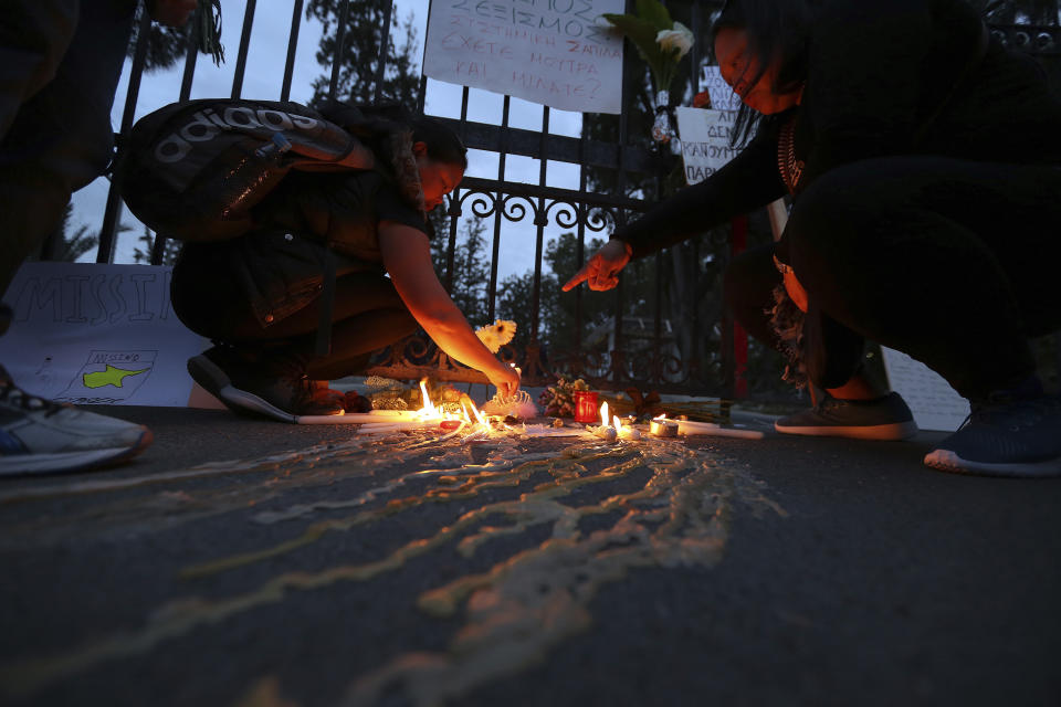 Women from the Philippinse light candles in memory of victims outside of the presidential palace in capital Nicosia, Cyprus, Friday, April 26, 2019. Up to 1,000 people turned out in front of Cyprus' presidential palace to remember the five foreign women and 2 girls that a military officer has confessed to killing in what police are again calling "an unprecedented crime." (AP Photo/Petros Karadjias)