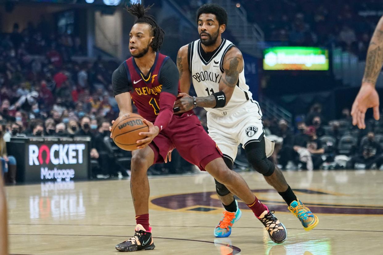 Cleveland Cavaliers' Darius Garland, left, drives against Brooklyn Nets' Kyrie Irving (11) in the first half of an NBA basketball game, Monday, Jan. 17, 2022, in Cleveland. (AP Photo/Tony Dejak)