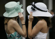FILE - Shelby Wilkes, left, and Pam Deegan, both of Louisville, Ky., holds their hats from the wind during the 134th Kentucky Derby Saturday, May 3, 2008, at Churchill Downs in Louisville, Ky. The first Saturday in May is Derby Day with all its accompanying pageantry, including fancy hats. (AP Photo/Amy Sancetta, File)