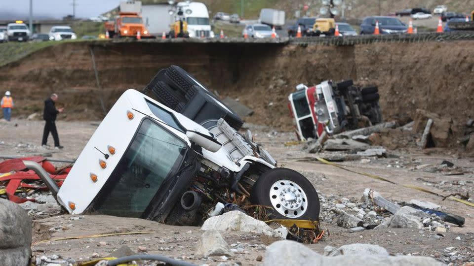 A truck and a fire engine fell from a highway after it collapsed due to heavy rain. Source: AP