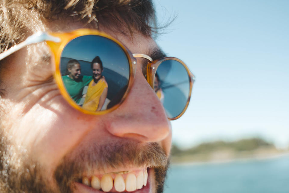 People's reflections in someone's sunglasses