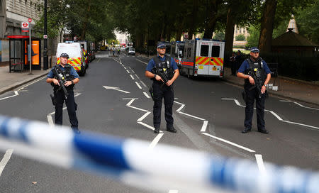 Armed police officers stand at a cordon after a car crashed outside the Houses of Parliament in Westminster, London. REUTERS/Hannah McKay