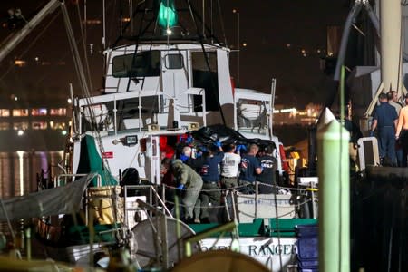 FILE PHOTO: Rescue personnel return to shore with the victims of a pre-dawn fire that sank a commercial diving boat off the coast of Santa Barbara, California