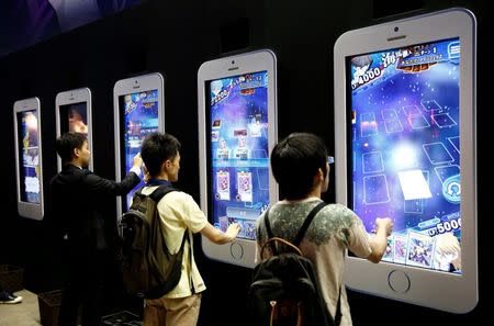 People play video games on mobile phone-shaped screens at Tokyo Game Show 2016 in Chiba, east of Tokyo, Japan, September 15, 2016. REUTERS/Kim Kyung-Hoon