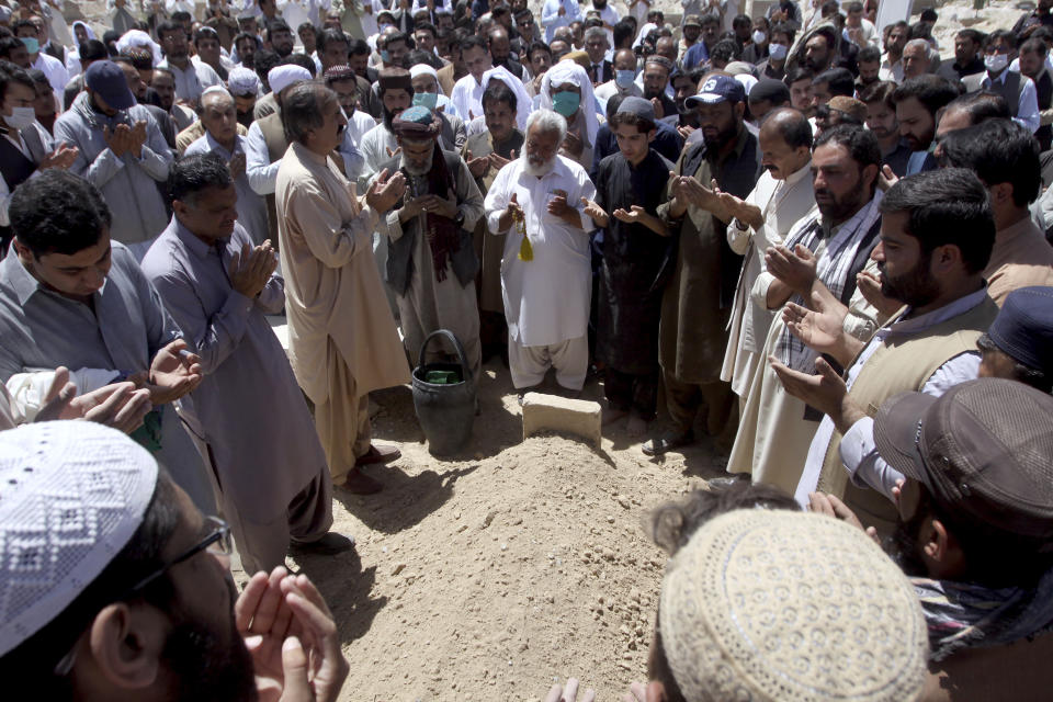 People pray at the grave of a victim who was killed in the Wednesday bomb blast in a luxury hotel in Quetta, Pakistan, Thursday, April 22, 2021. An attack at a luxury hotel in Pakistan has been confirmed as a suicide car bombing, and the death toll has risen to five, police said Thursday. (AP Photo/Arshad Butt)