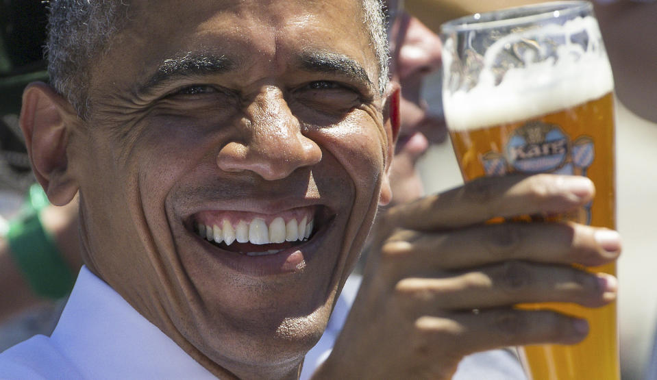 President Barack Obama enthusiastically raises a glass of beer.