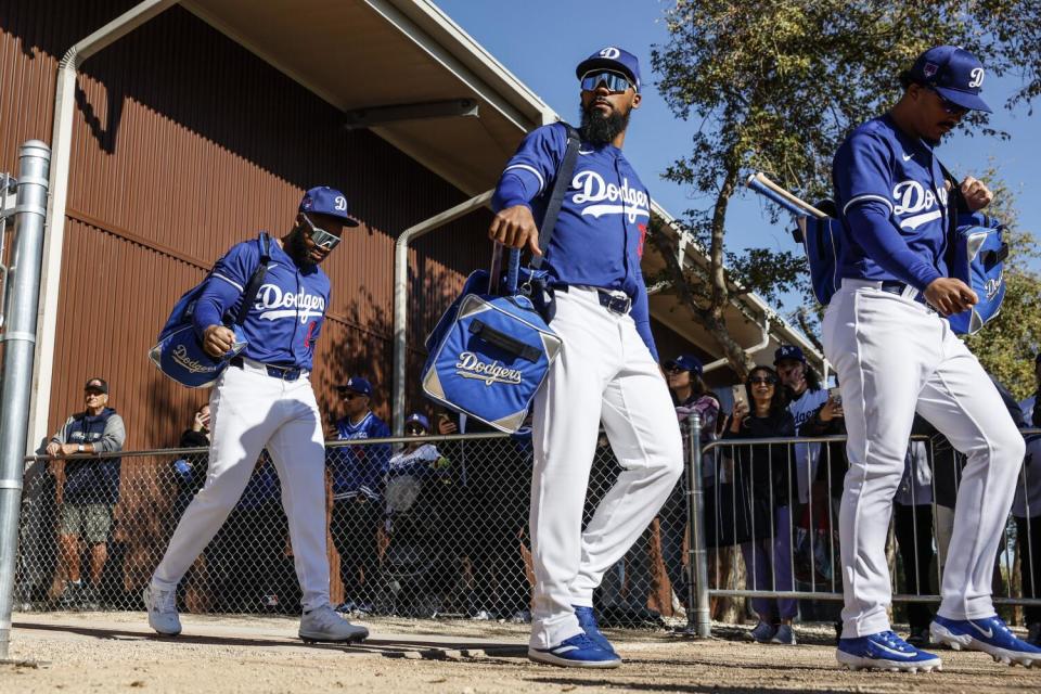 Teoscoar Hernandez, center, arrives with teammates Manuel Margot, left, and Miguel Vargas, right.