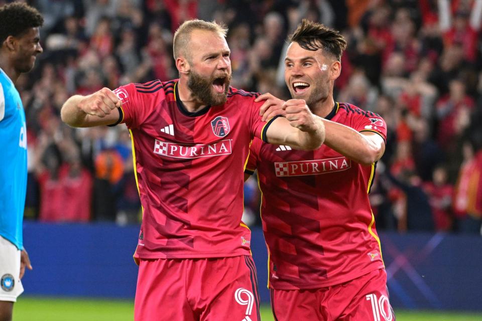 St. Louis City SC forward Klauss (9) and midfielder Eduard Lowen (10) celebrate after Charlotte FC scored an own goal during the first half of an MLS soccer match Saturday, March 4, 2023, in St. Louis. (AP Photo/Joe Puetz)