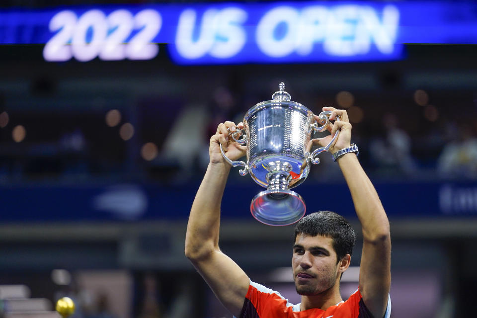 Carlos Alcaraz, of Spain, holds up the championship trophy after defeating Casper Ruud, of Norway, in the men's singles final of the U.S. Open tennis championships, Sunday, Sept. 11, 2022, in New York. (AP Photo/Matt Rourke)