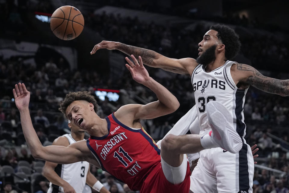 New Orleans Pelicans guard Dyson Daniels (11) is blocked and fouled by San Antonio Spurs forward Julian Champagnie (30) during the second half of an NBA basketball game in San Antonio, Sunday, Dec. 17, 2023. (AP Photo/Eric Gay)