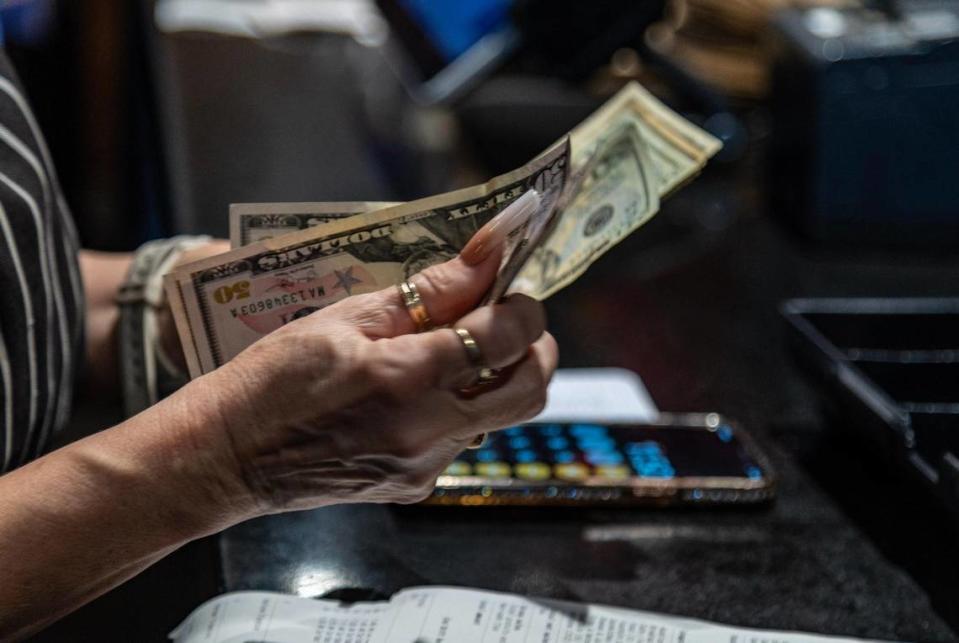 A waitress counts some money as she closes her shift at the Latin Cafe 2000 in Miami. Pedro Portal/pportal@miamiherald.com