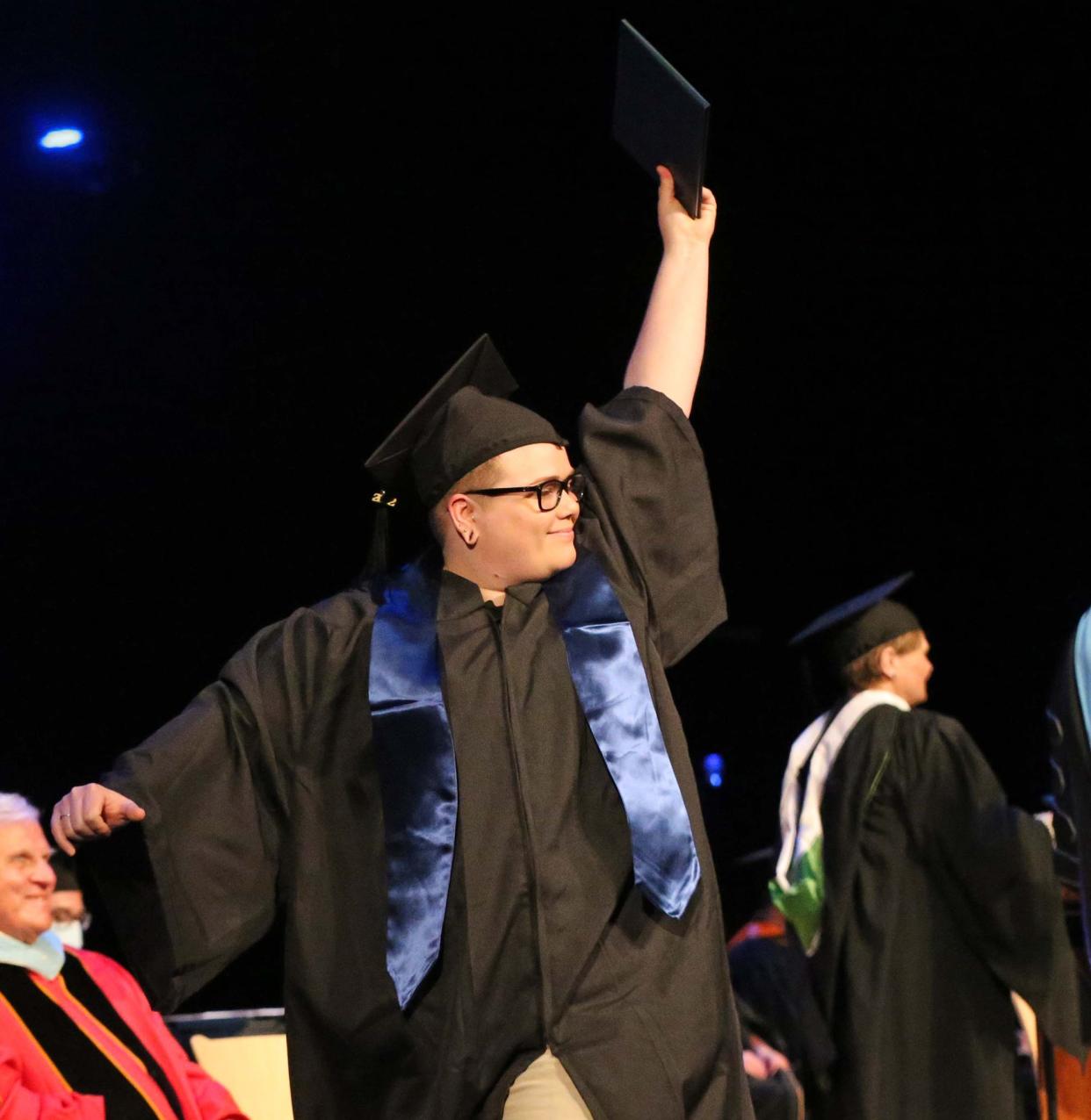 Graduates cross the stage and show off their diplomas during the 27th annual commencement address for York County Community College May 13, 2022.