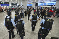 Police officers patrol as passengers queue at the departure hall of the high speed train station in Hong Kong, Friday, Jan. 24, 2020 to celebrate the Lunar New Year which marks the Year of the Rat in the Chinese zodiac. Cutting off access to entire cities with millions of residents to stop a new virus outbreak is a step few countries other than China would consider, but it is made possible by the ruling Communist Party's extensive social controls and experience fighting the 2002-03 outbreak of SARS. (AP Photo/Achmad Ibrahim)