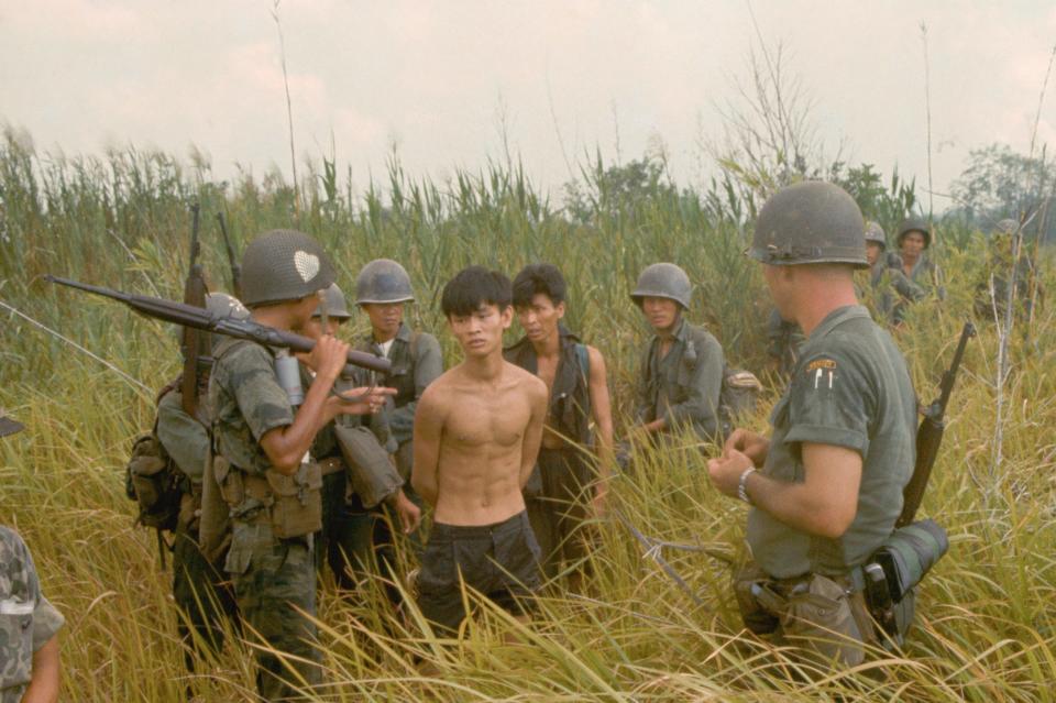 A Tim Page photo from 1965 showing a group of South Vietnamese soldiers and an American soldier with two captured Vietcong suspects - Tim Page/CORBIS/Corbis via Getty Images