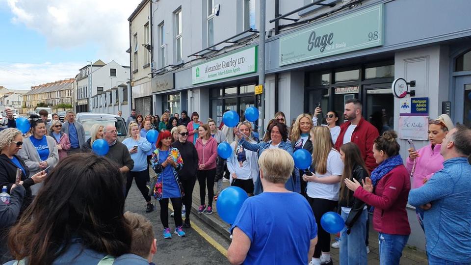 Group of people holding blue balloons