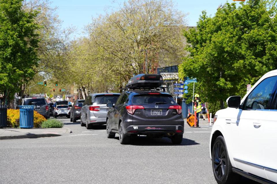 Traffic is slowed on Holly Street on Wednesday, May 1, 2024, as cars are limited to one lane while crews install bike lanes on the street between Ellis and Prospect in downtown Bellingham, Wash.