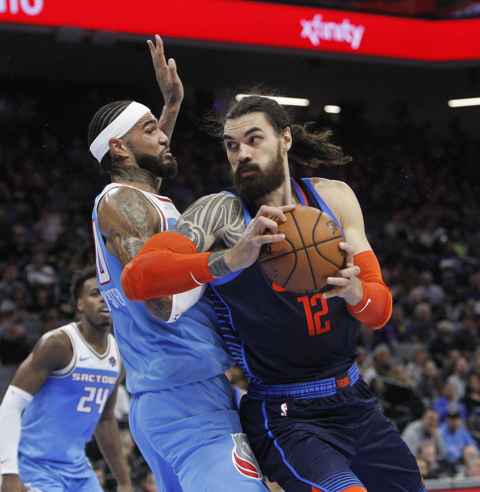 Oklahoma City Thunder center Steven Adams (12) battles for position against Sacramento Kings center Willie Cauley-Stein (00) during the first half of an NBA basketball game in Sacramento, Calif., Wednesday, Dec. 19, 2018. (AP Photo/Steve Yeater)