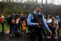 Honduran migrants queue to show their identification to the officials near to the Agua Caliente border, hoping to cross into Guatemala and join a caravan trying to reach the U.S, in the municipality of Ocotepeque, Honduras October 17, 2018. REUTERS/Jorge Cabrera