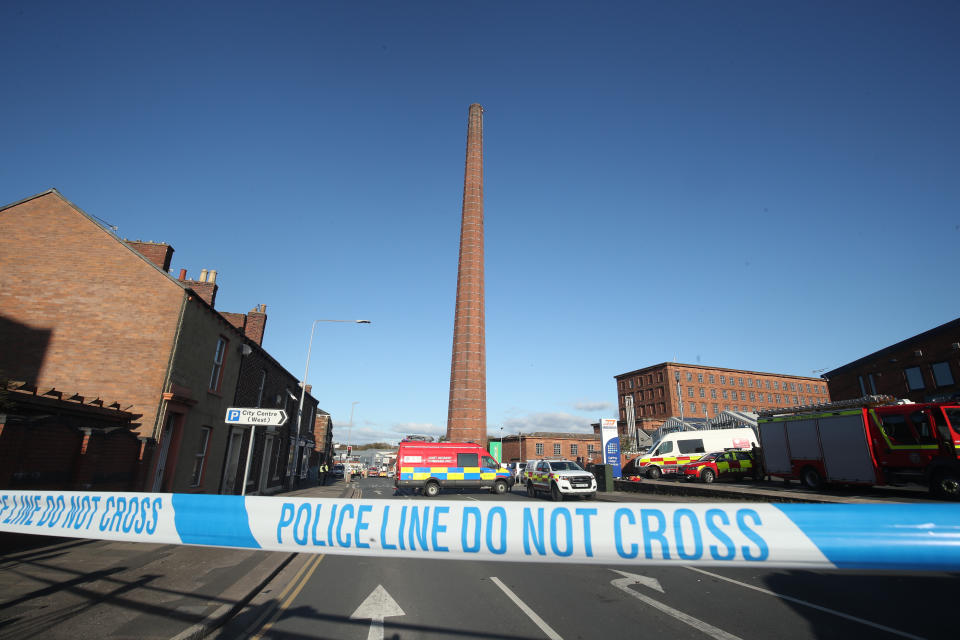 Emergency vehicles block the road near to Dixon's Chimney in Carlisle, Cumbria, where a man, whose condition is currently unknown, continues to hang upside down from the top of the chimney 270ft up.