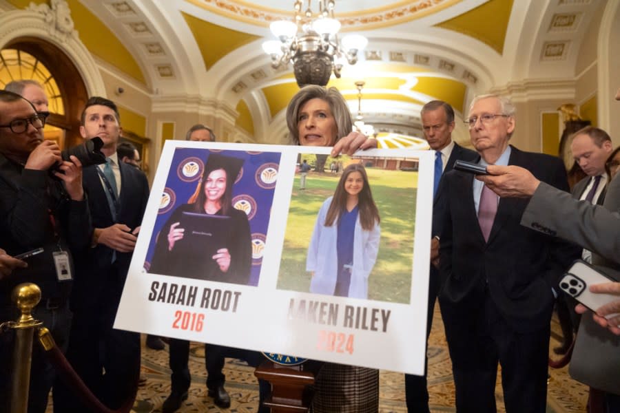 Sen. Joni Ernst, R-Iowa, holds a poster with photos of murder victims Sarah Root and Laken Riley as she speaks after a policy luncheon on Capitol Hill, Tuesday, Feb. 27, 2024, in Washington. (AP Photo/Mark Schiefelbein)