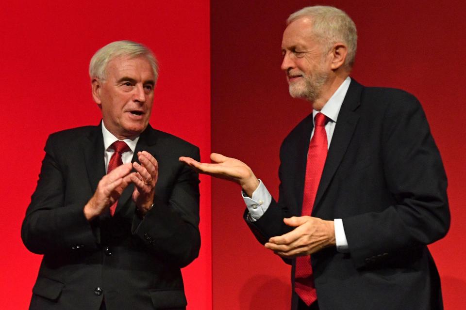 Labour Party Leader Jeremy Corbyn gestures to Mr McDonnell after the latter's speech 