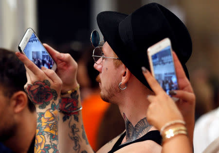 Guests use mobile phones during the Atsushi Nakashima Spring/Summer 2018 show at the Milan Fashion Week in Milan, Italy, September 20, 2017. REUTERS/Stefano Rellandini