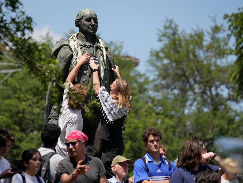 Protesters place a sign on the George Washington statue at a pro-Palestinian protest at the University of Texas Monday April 29, 2024.