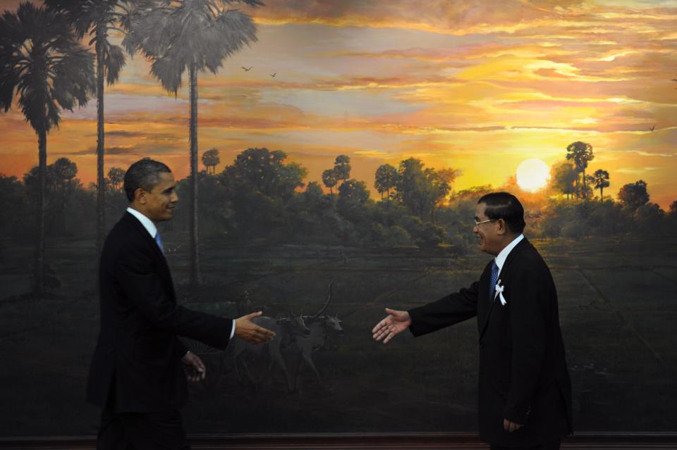 U.S. President Barack Obama (L) and Cambodian Prime Minister Hun Sen (R) reach out to shake hands on arrival at the Peace Palace for the Association of Southeast Asian Nations (ASEAN) and US summit in Phnom Penh on Nov. 19, 2012 following the 21st ASEAN Leaders Summit.