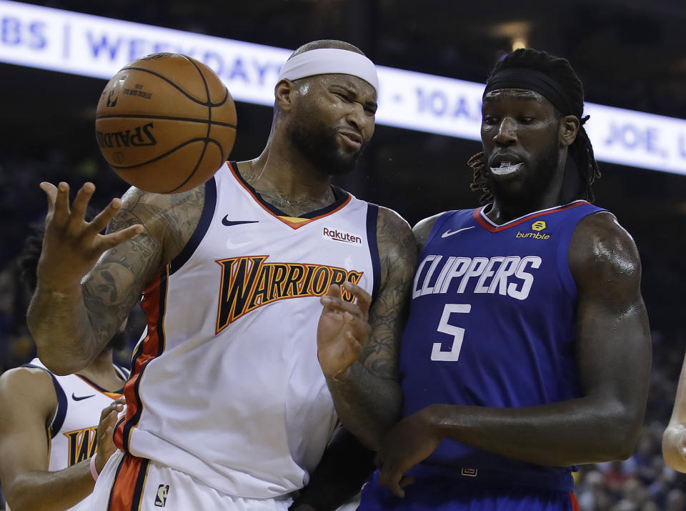 Golden State Warriors' DeMarcus Cousins, left, reacts to a foul called against him beside Los Angeles Clippers' Montrezl Harrell (5) in the first half of an NBA basketball game Sunday, April 7, 2019, in Oakland, Calif. (AP Photo/Ben Margot)