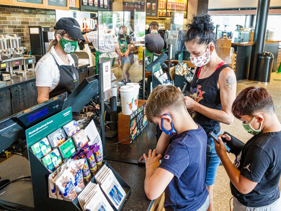 Florida, Orlando, Starbucks Coffee shop, mom with sons at cashier, all wearing face masks
