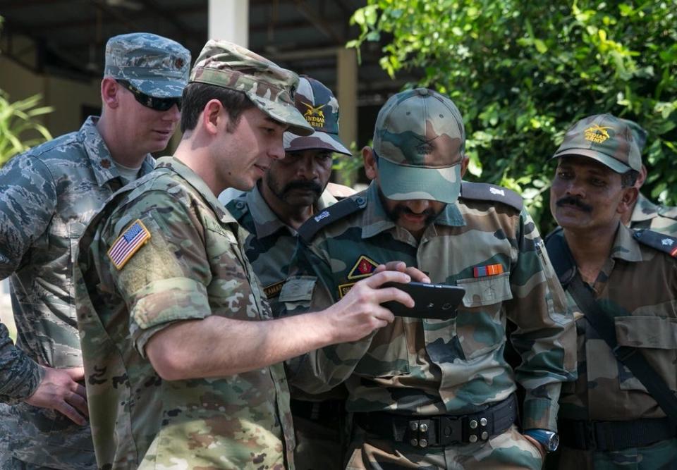 Then-Lt. Canyon Yeamans from the 83rd Civil Affairs Battalion, shows photos to leaders of the Indian Army at Ban Non Lueam School in Korat Province Jan. 27, 2017 during annual multilateral training exercise Cobra Gold 2017.