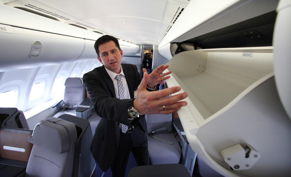 Lufthansa program manager for cabin development Steffen Voltz explains the larger overhead bins before delivery by Boeing of the first 747-8 Intercontinental Tuesday, May 1, 2012, in Everett, Wash. Lufthansa is the launch customer for the Intercontinental and will start service with the airplane between Frankfurt, Germany and Washington, D.C. The 747-8 Intercontinental is a stretched, updated version of the iconic 747 and is expected to bring double-digit improvements in fuel burn and emissions over its predecessor, the 747-400, and generate 30 percent less noise. Boeing delivered the first 747-8 Intercontinental to a private customer in February, more than a year after originally planned. (AP Photo/Elaine Thompson)