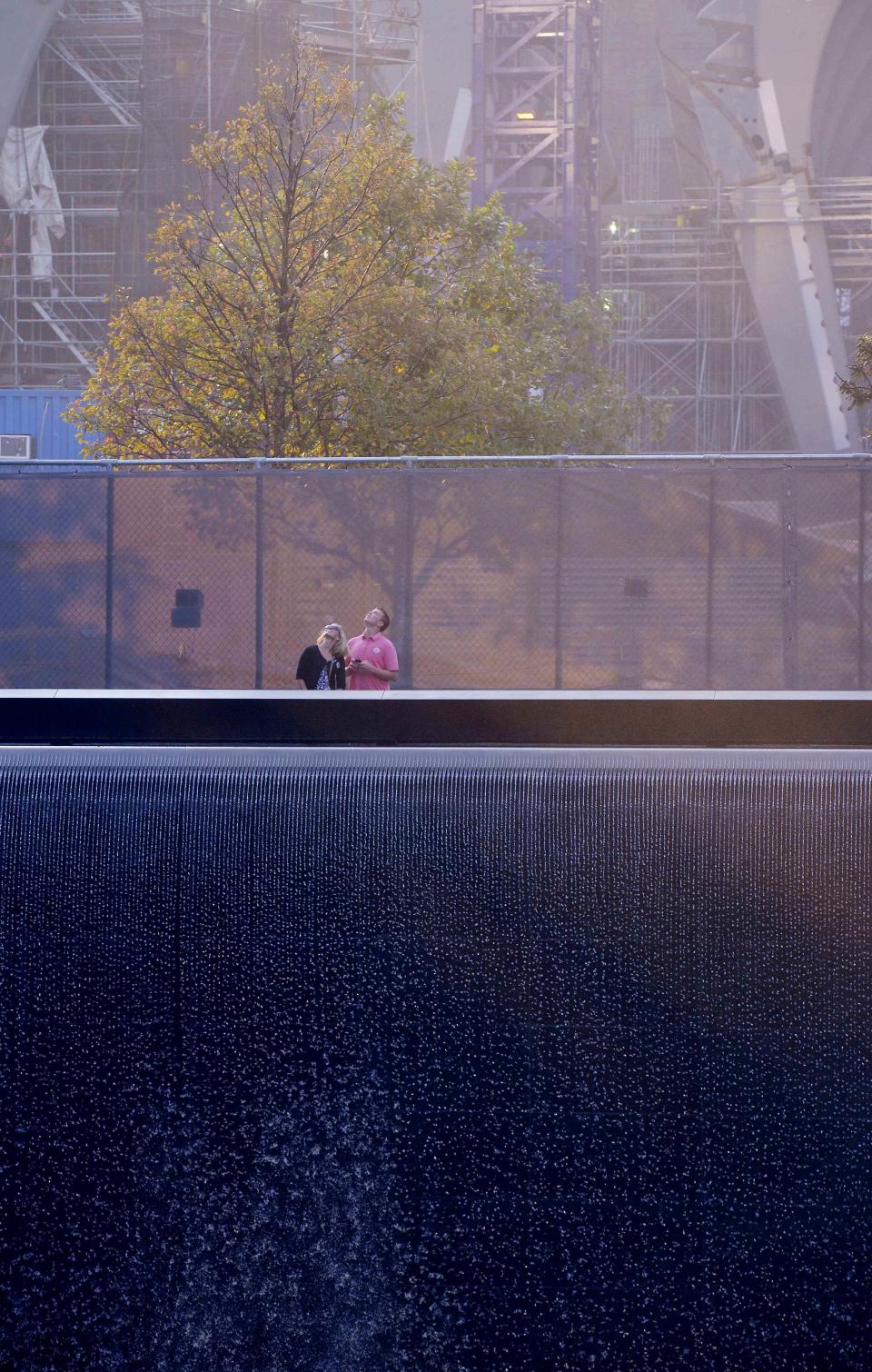 Two people stand at the edge of the North Pool at the 9/11 Memorial during a ceremony marking the 12th anniversary of the 9/11 attacks on the World Trade Center in New York, September 11, 2013. (REUTERS/Justin Lane)