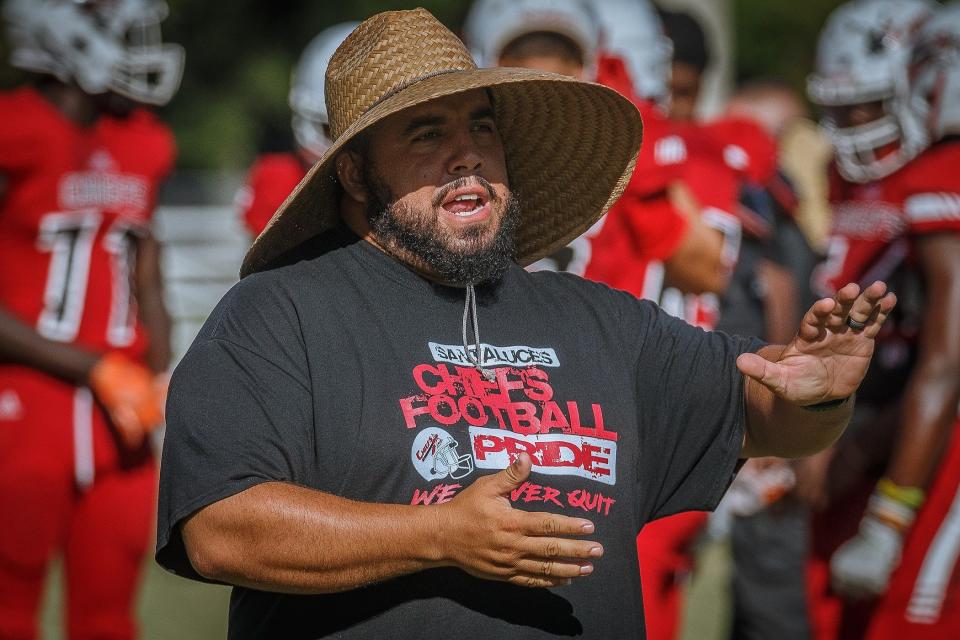 Santaluces Community High School head coach Hector Clavijo III explains a play during high school football summer workouts at Lake Lytal Park in unincorporated Palm Beach County, on Thursday, July 21, 2022.