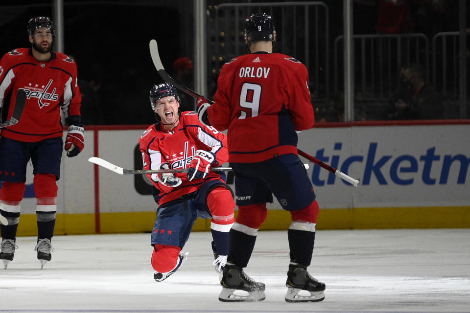 Washington Capitals center Evgeny Kuznetsov, center, celebrates his goal with Dmitry Orlov during the second period of an NHL hockey game against the Calgary Flames, Saturday, Oct. 23, 2021, in Washington. (AP Photo/Nick Wass)