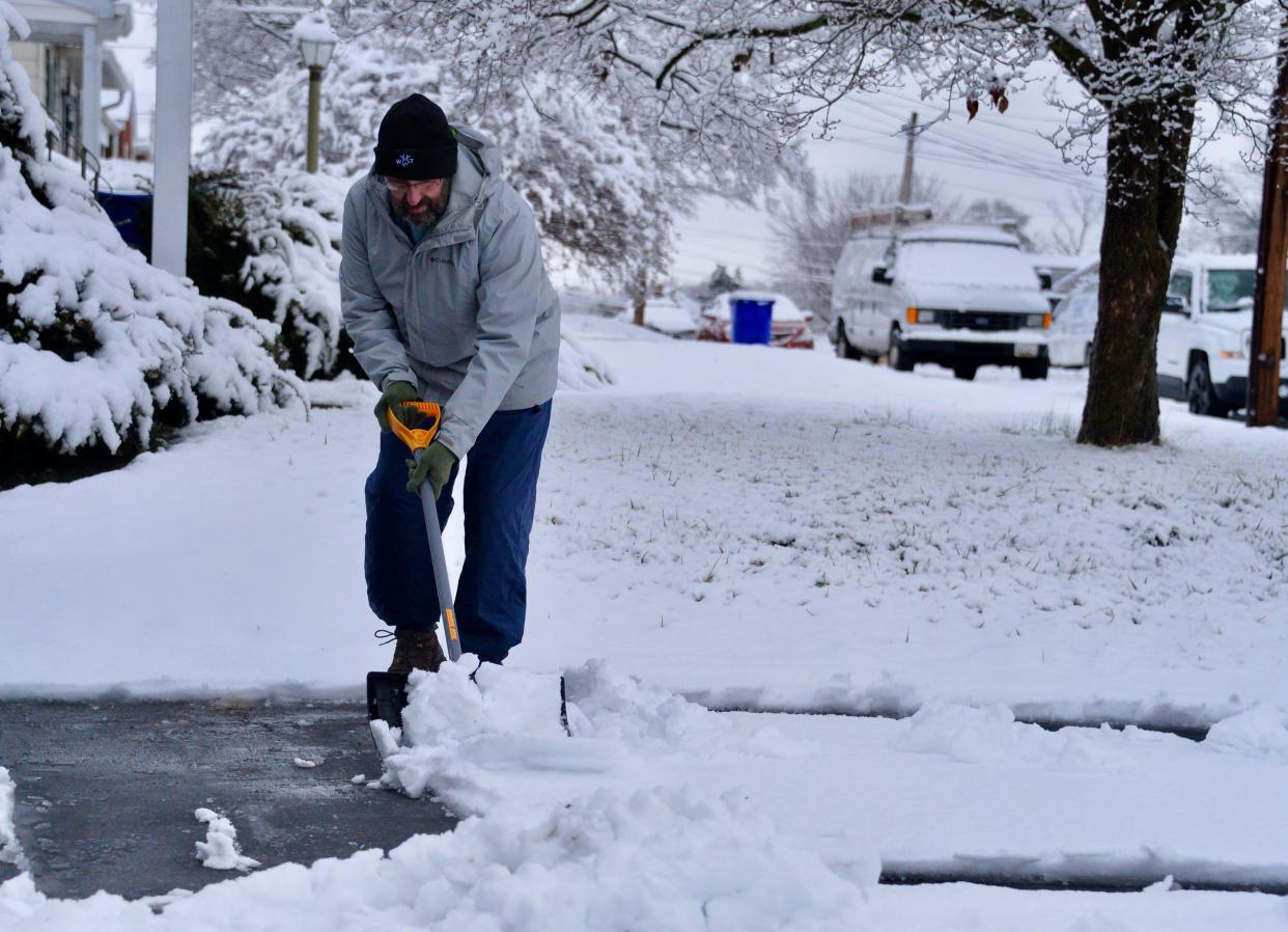 David Souza shovels snow from his driveway Feb. 13, 2024, after a snowstorm dropped heavy, wet snow in the Hagerstown, Maryland, area.