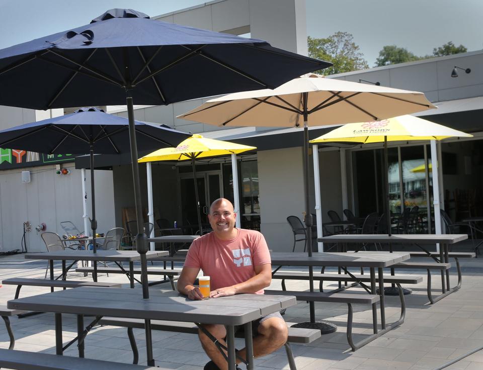 Alex Gilbert Aviles, owner of WHYM Craft Pub & Brewery, sits on the brand-new patio, continuing a trend of places along Route 1 who have leaned into outdoor dining since the pandemic.