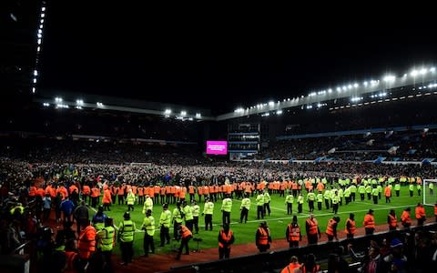 Security attempt to clear the ground from the fans of Aston Villa after a pitch invasion during the Carabao Cup Semi Final match between Aston Villa and Leicester City  - Credit: &nbsp;Shaun Botterill/Getty Images