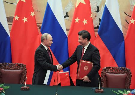 Chinese President Xi Jinping shakes hands with his Russian counterpart Vladimir Putin during a signing ceremony after their meeting in Beijing, China, June 25, 2016. Sputnik/Kremlin/Mikhail Klimentyev/via REUTERS