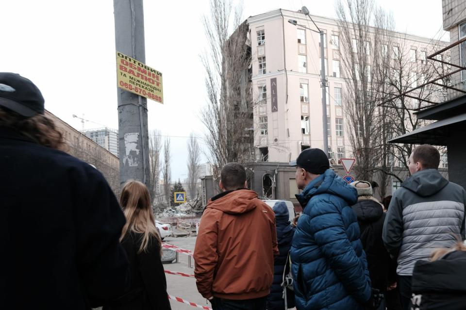 Kyiv residents look out at a destroyed building that was struck by a Russian missile on New Year’s Day (Getty Images)