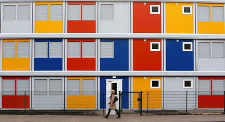 FILE PHOTO - A pedestrian walks past a new refugee centre for housing asylum seekers in the Koepenick district of Berlin, Germany January 2, 2015. REUTERS/Fabrizio Bensch/File Photo