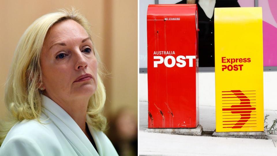Christine Holgate gives evidence on her departure from Australia Post while wearing white, Australia Post mail boxes. 